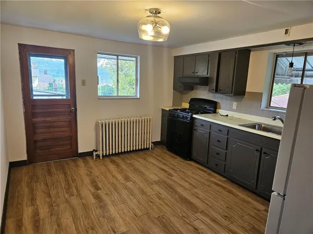 a kitchen with a sink a refrigerator and window