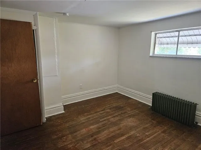 an empty room with wooden floor and closet