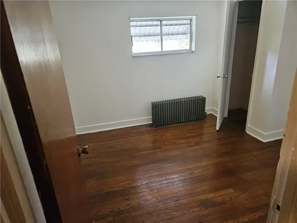 an empty room with wooden floor and closet