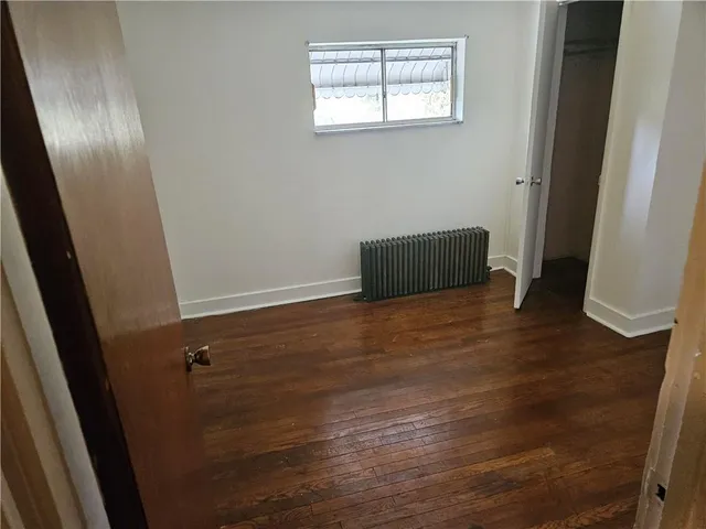 an empty room with wooden floor and closet