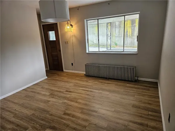 a view of a room with wooden floor and mirror