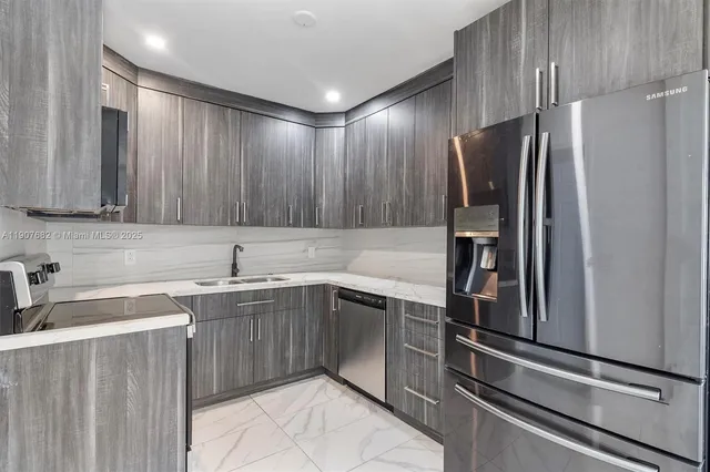 a kitchen with kitchen island a sink stainless steel appliances and cabinets