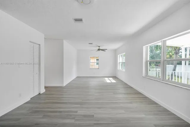 wooden floor in an empty room with a window