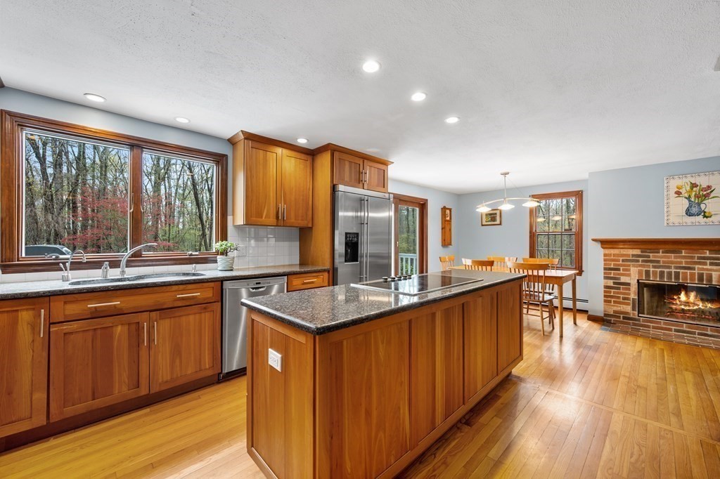 21 Adams Road Boxford, MA 01921 - Photo 3 of 40 a kitchen with stainless steel appliances granite countertop wooden cabinets a sink a stove a dining table and chairs
