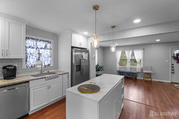 a kitchen with a sink a counter space appliances and cabinets