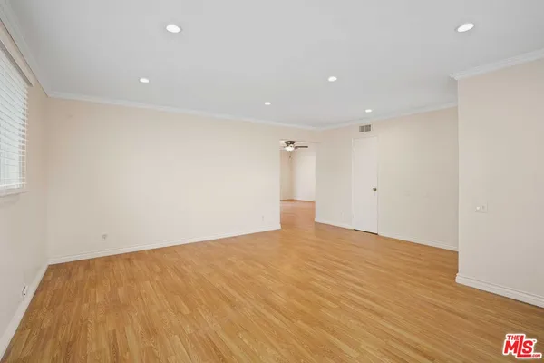 a view of an empty room with wooden floor