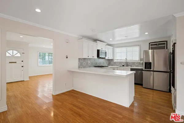 a kitchen with granite countertop a refrigerator and a stove top oven