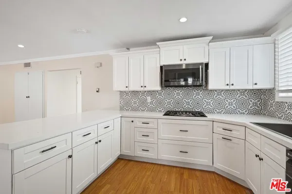 a kitchen with white cabinets and white appliances