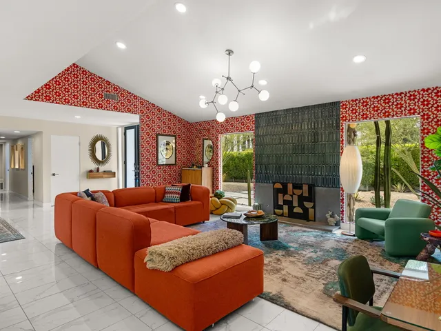 a living room with furniture a fireplace and a chandelier