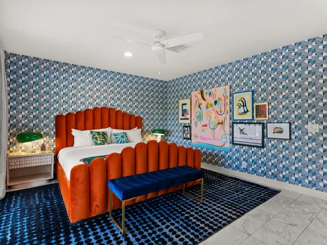 a bedroom with a bed and painting on the wall