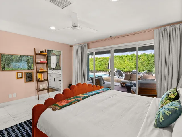 a bedroom with a bed and large windows