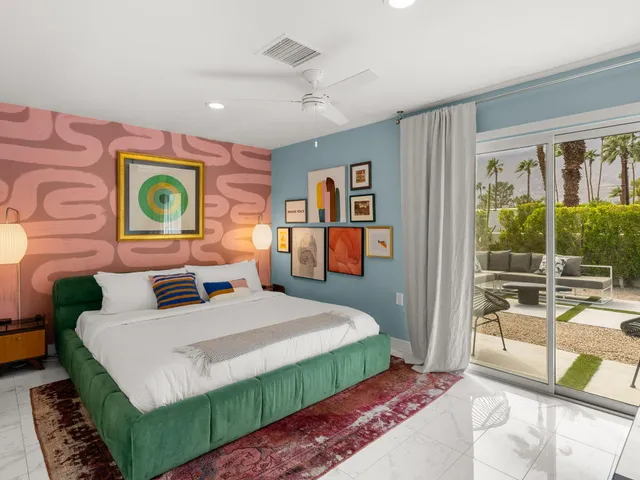 a bedroom with a bed mirror and a large window