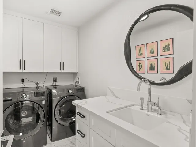 a utility room with sink dryer and washer