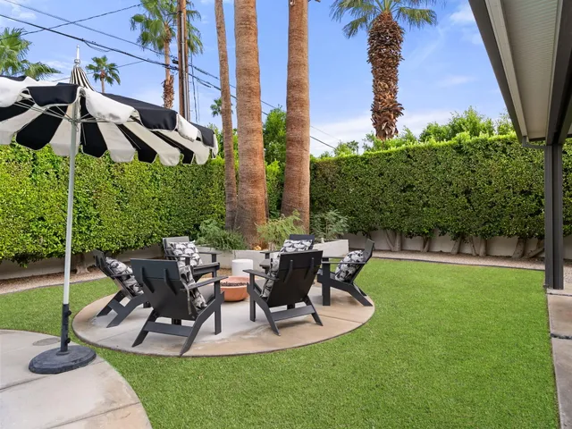 a view of a chair and table in backyard of the house