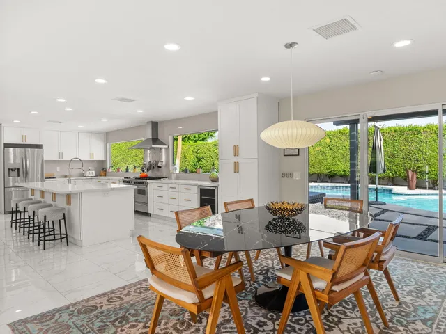 a dining room with furniture and a large window