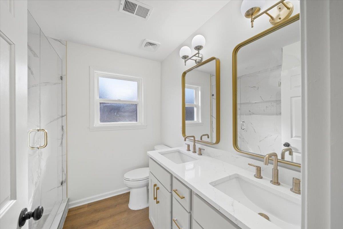 1676 Miller Farms Road Germantown, TN 38138 - Photo 25 of 37 Bathroom featuring a double vanity with undermount sinks, gold-finish hardware, and a wood-finish floor