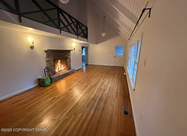 a view of empty room with wooden floor