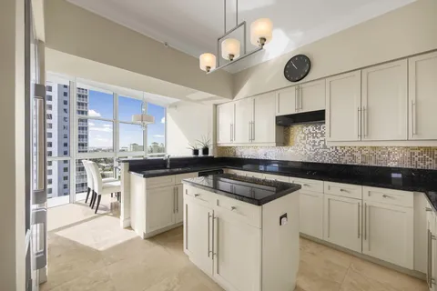 a kitchen with a sink dishwasher and white cabinets with wooden floor