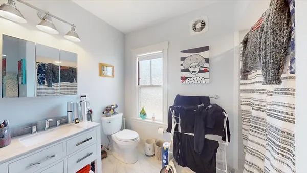 a bathroom with a toilet a sink and mirror
