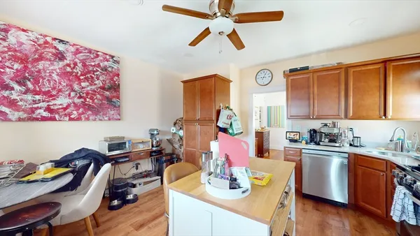 a dining room with stainless steel appliances kitchen island granite countertop furniture and wooden floor