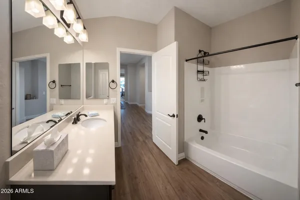 a bathroom with a tub a sink and mirror