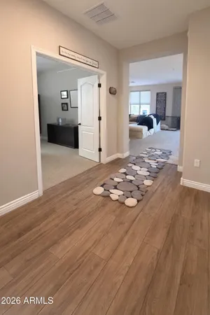 a view of a livingroom with wooden floor and a bathroom