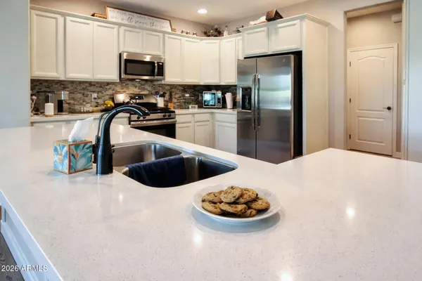 a kitchen with stainless steel appliances a refrigerator sink and stove