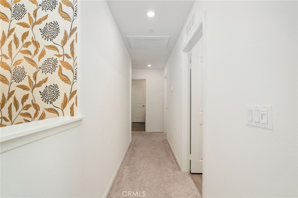 13430 Limestone Drive Yucaipa, CA 92399 - Photo 17 of 30 a view of a hallway with wooden floor and a bathroom