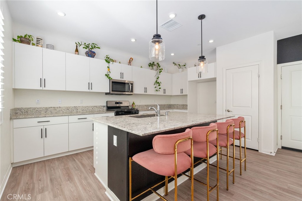 13430 Limestone Drive Yucaipa, CA 92399 - Photo 10 of 30 a kitchen with stainless steel appliances granite countertop a white cabinets and a stove