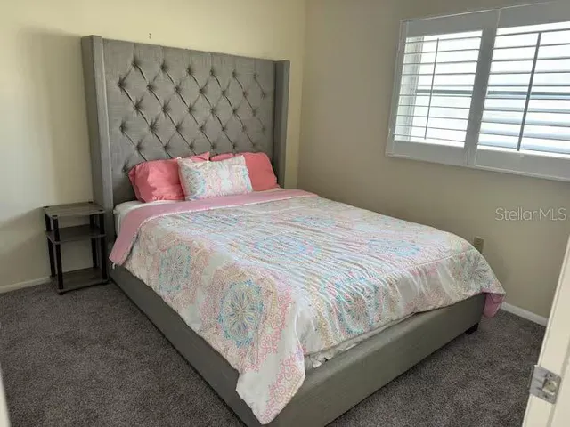 a large bed sitting in a bedroom next to a window