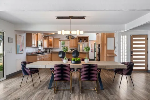 a kitchen with stainless steel appliances granite countertop a sink a stove and a wooden floors