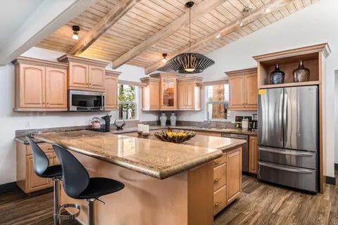 a kitchen with granite countertop a stove a sink and a refrigerator