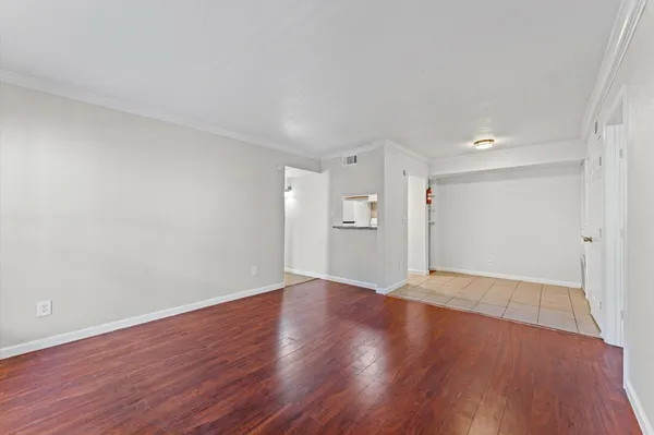 a view of an empty room with wooden floor