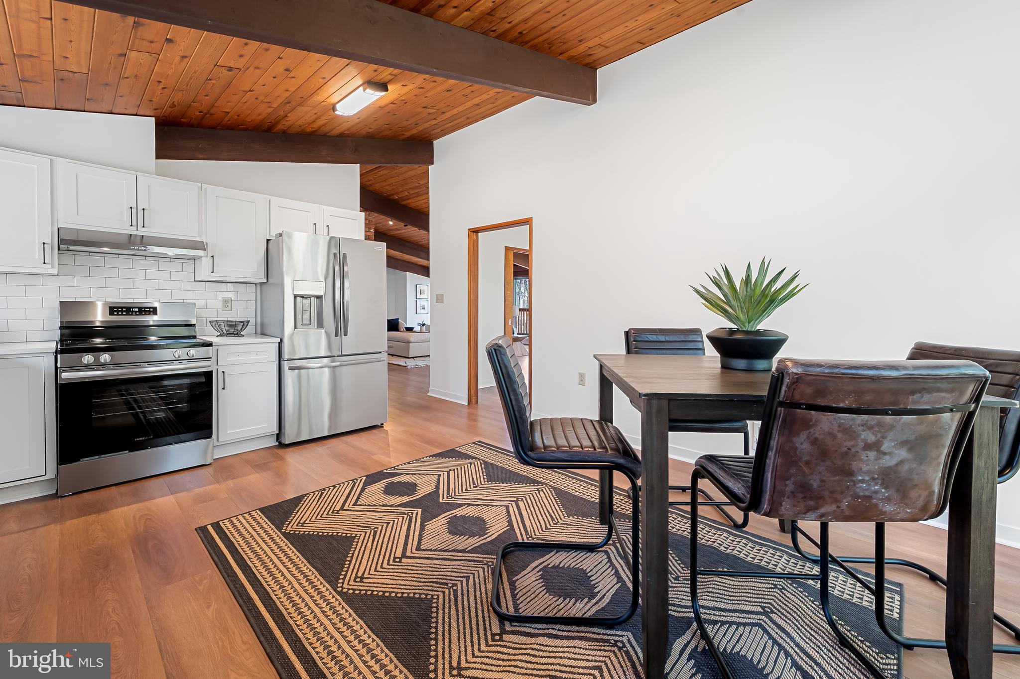 1817 Falls Road Parkton, MD 21120 - Photo 12 of 50 a kitchen with stainless steel appliances granite countertop a stove a refrigerator a dining table and chairs with wooden floor