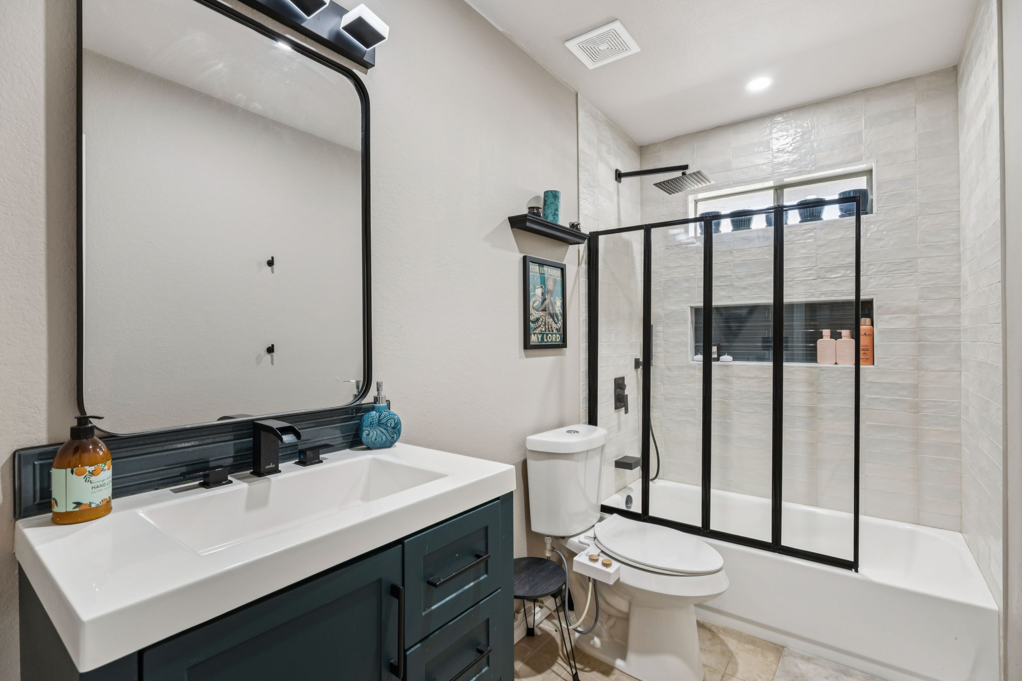 2412 Chestnut Path Round Rock, TX 78664 - Photo 15 of 26 A well-appointed bathroom offers a sleek vanity, modern mirror, and a combination tub and shower with clear glass enclosure.