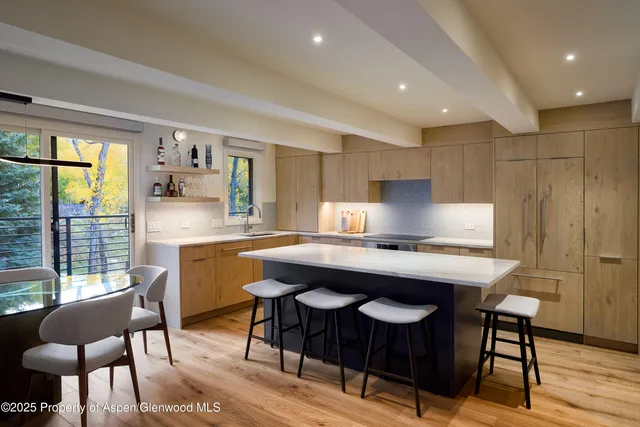 a kitchen with a table chairs sink and cabinets