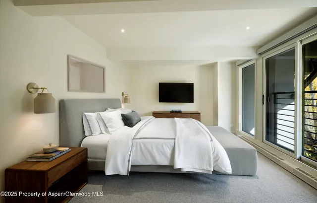 a bedroom with a bed couch and a window