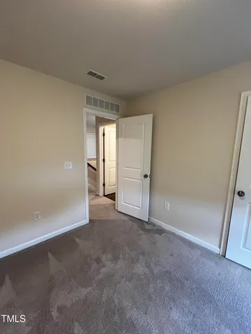 a view of an empty room and closet area