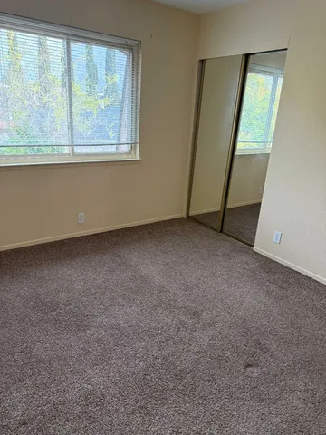 an empty room with wooden floor and closet