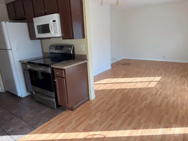 a kitchen with a wooden floor and a stove top oven