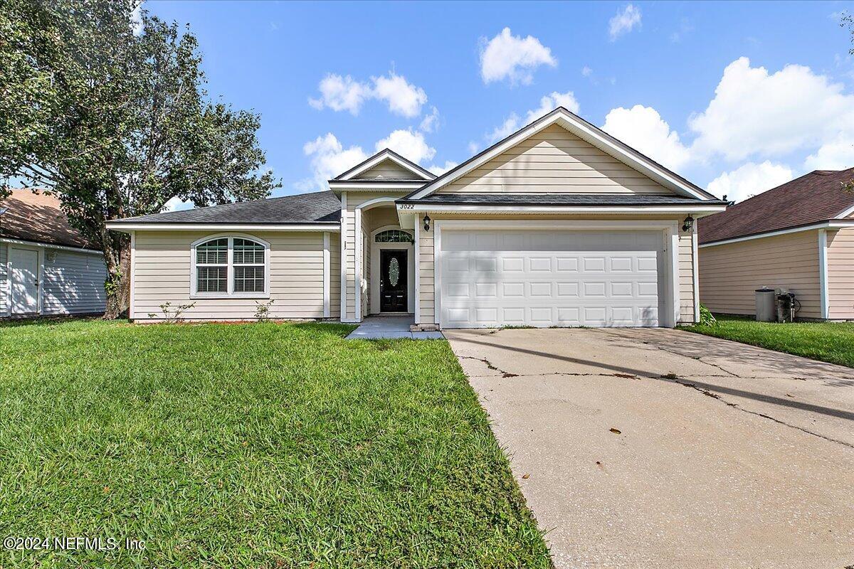 a front view of a house with a yard and garage