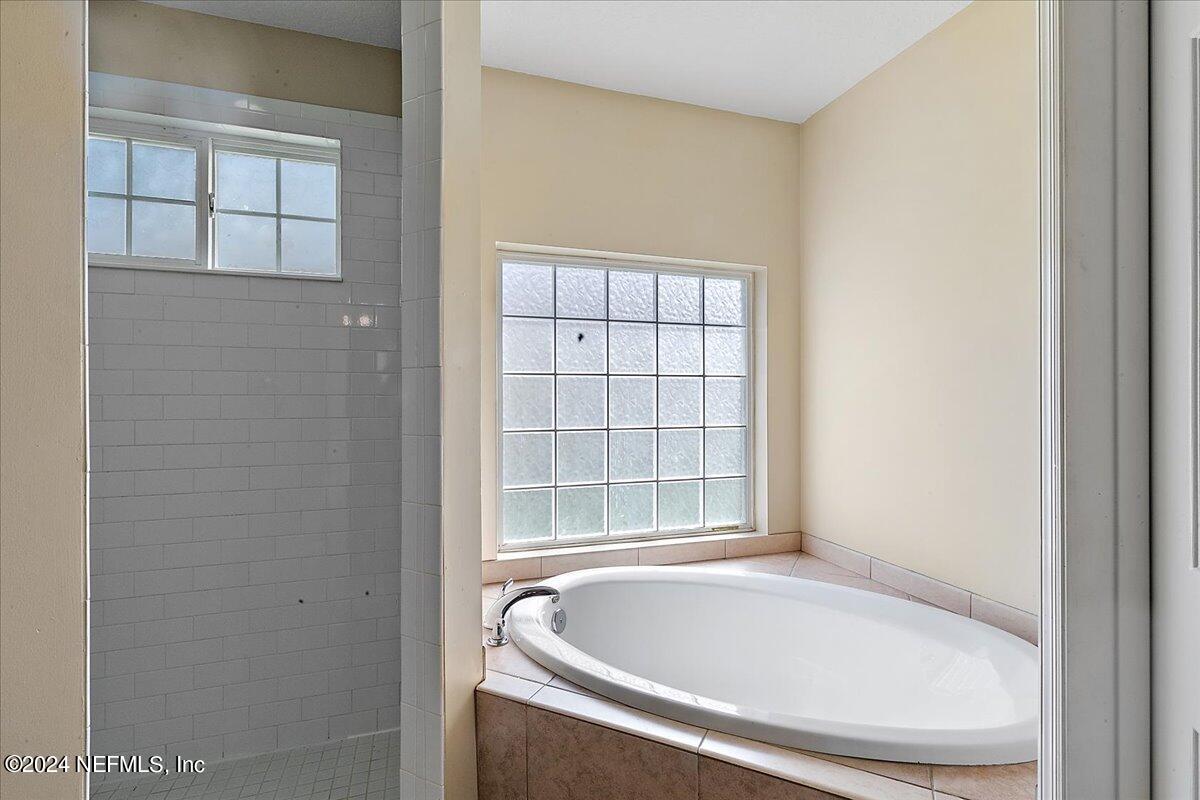 3022 Waters View Circle Orange Park, FL 32073 - Photo 15 of 17 a white bath tub sitting in a bathroom next to a window
