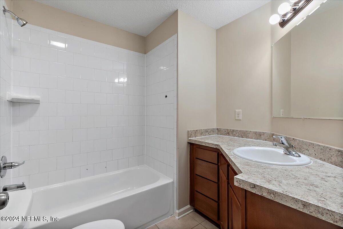 3022 Waters View Circle Orange Park, FL 32073 - Photo 4 of 17 a bathroom with a granite countertop sink a mirror a bathtub and shower