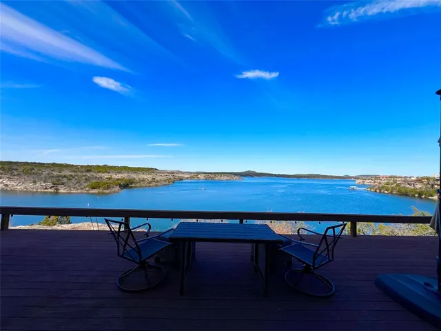 a view of a lake with table and chairs