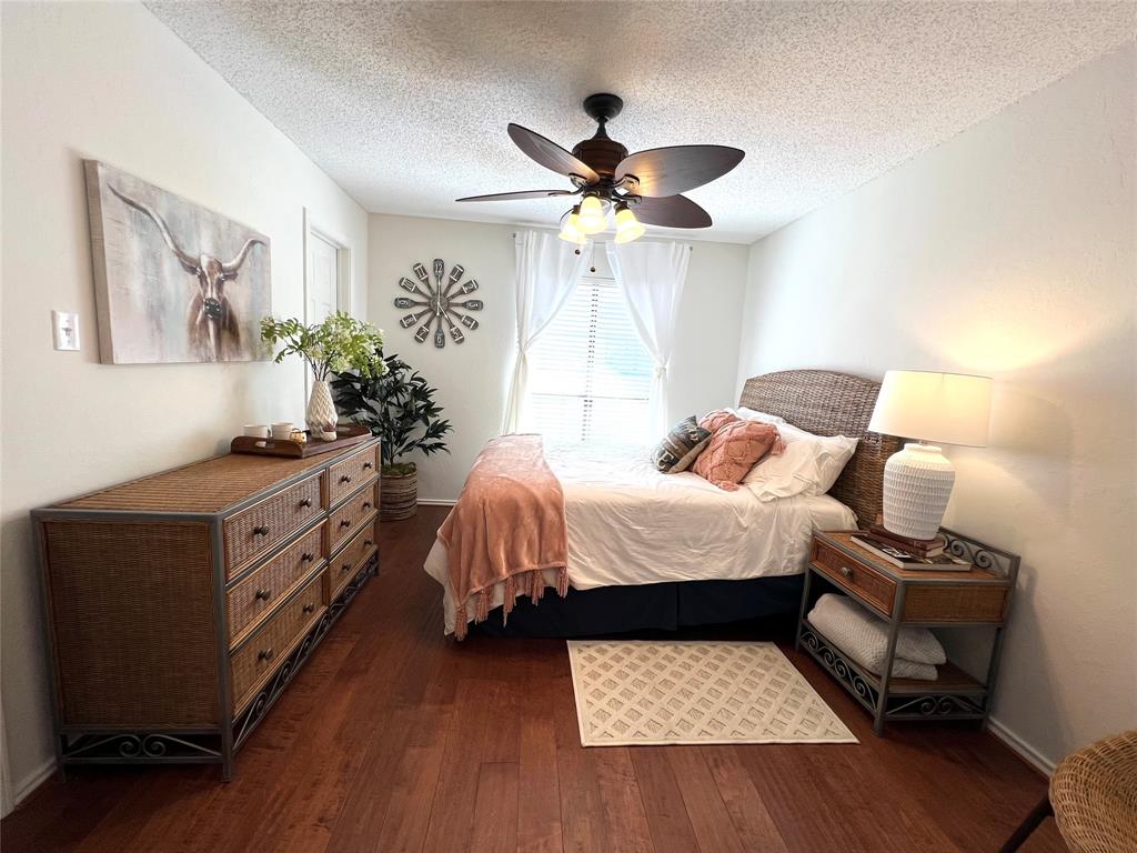 3123 Hells Gate Loop, Unit 45 Strawn, TX 76475 - Photo 18 of 30 a bedroom with a bed and a chandelier