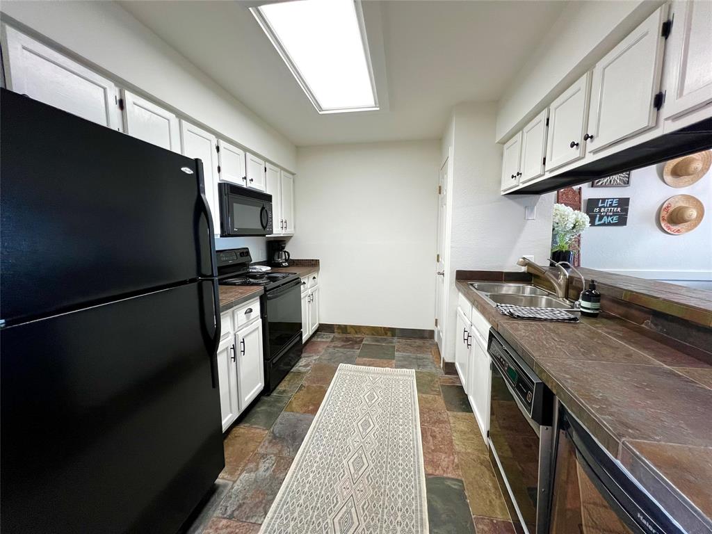 3123 Hells Gate Loop, Unit 45 Strawn, TX 76475 - Photo 7 of 30 a kitchen with a refrigerator and a sink