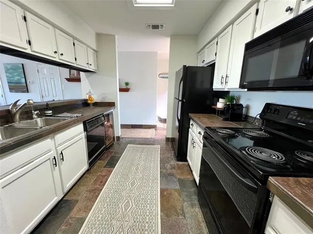 a kitchen with stainless steel appliances a sink dishwasher stove and refrigerator