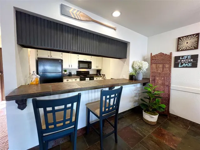 a kitchen with a table chairs and refrigerator