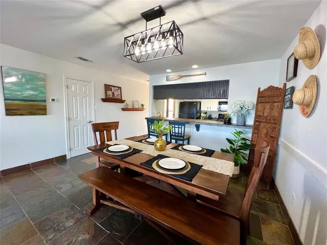 a view of a dining room with furniture a chandelier and wooden floor