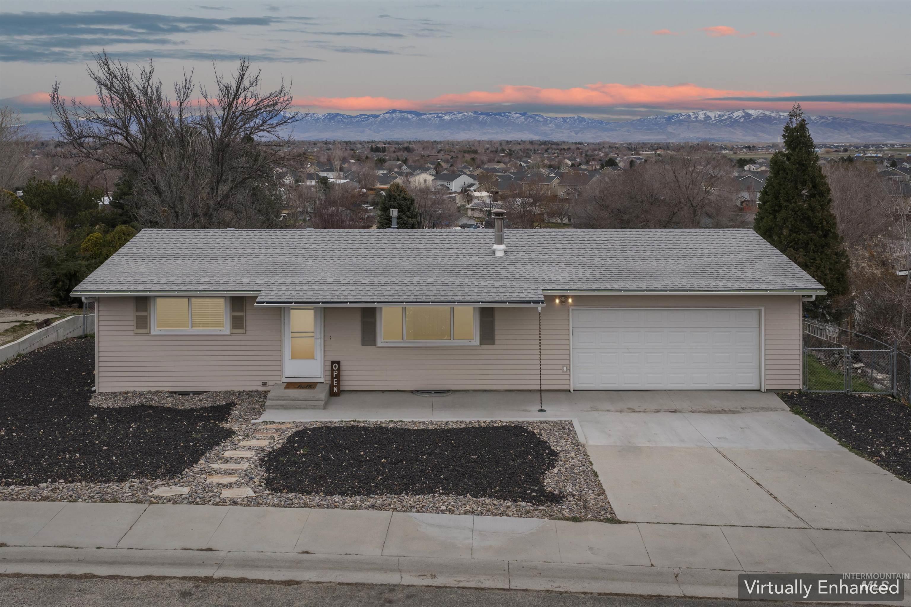 9988 West Fox Ridge Drive Boise, ID 83709 - Photo 1 of 1 Single story home featuring driveway, an attached garage, roof with shingles, and a mountain view